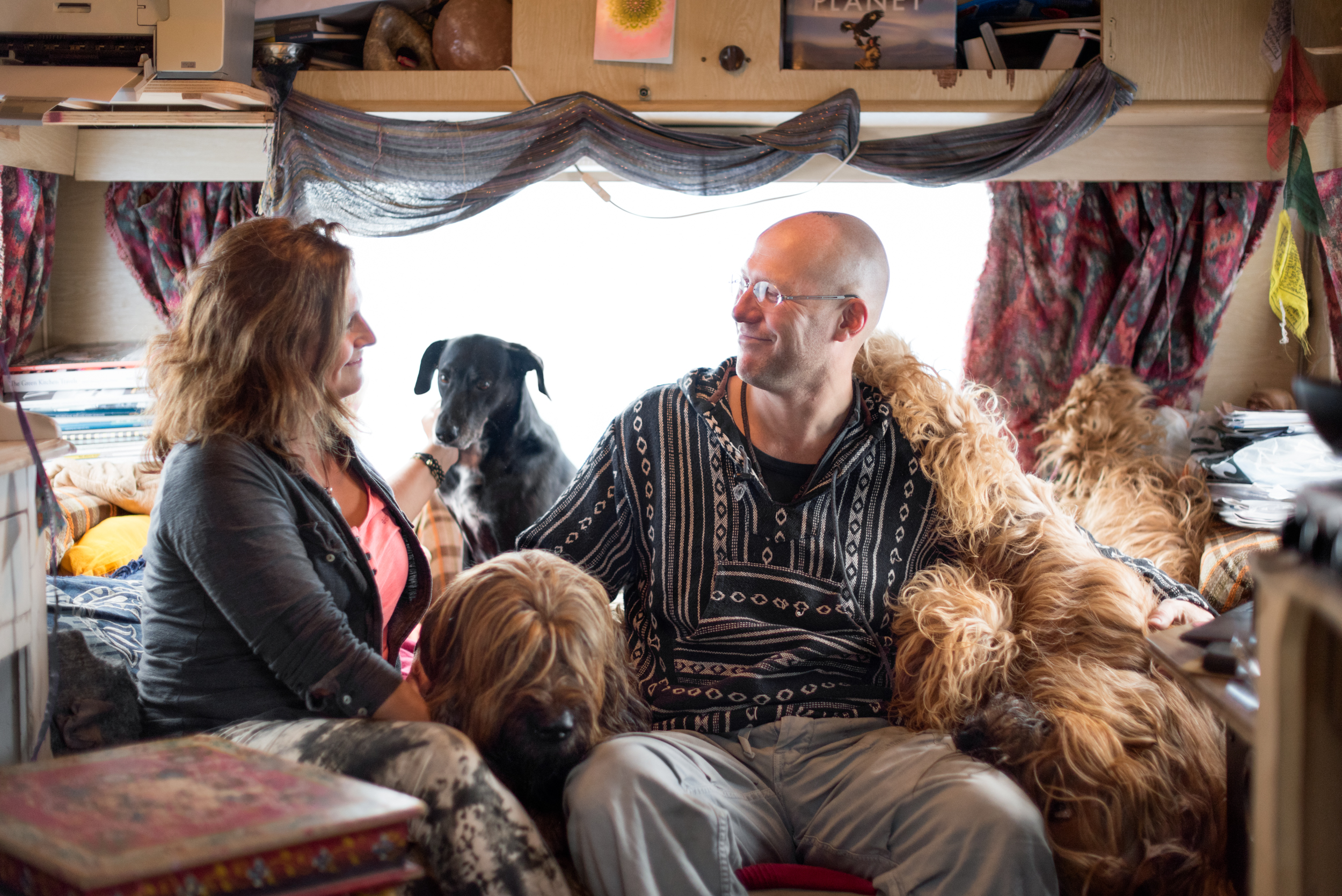 family and dog relaxing together on a sofa in their caravan